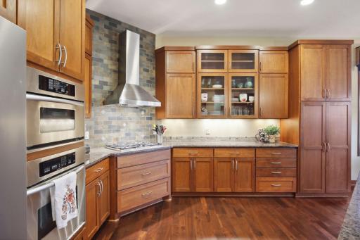 A gourmet Kitchen with walnut flooring, cheery cabinets, stainless appliances and gas range hood make this Kitchen extra special.