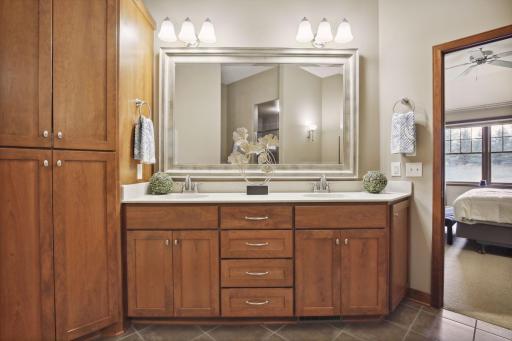 An owner's ensuite Bath with beautiful cherry cabinetry, double vanity, walk-in shower, soaking tub, walk-in closet with easy access to the Laundry Room.