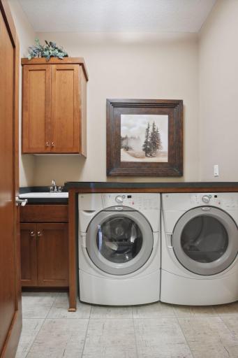 Super Laundry Room with sink, cherry cabinets and private entry from the back Foyer and Garage.