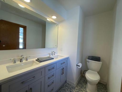 En Suite 1/2 bath with new vanity featuring dual sinks , new faucets , toilet & LED lighting.