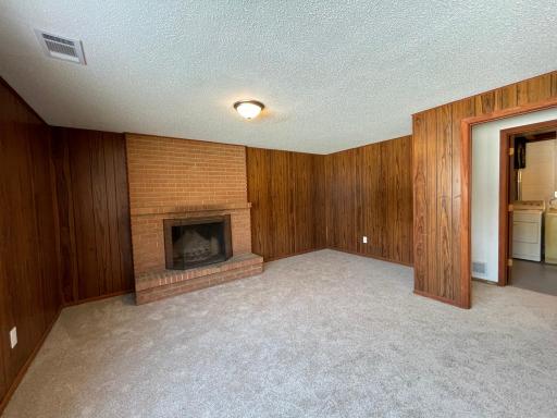 Lower level family room features new carpet and wood burning fireplace.