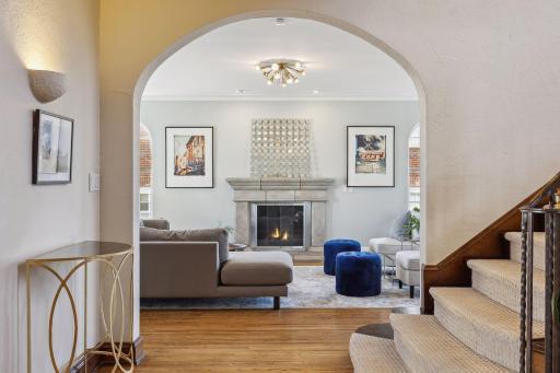 Family/living room with natural gas fireplace insert from main foyer and staircase