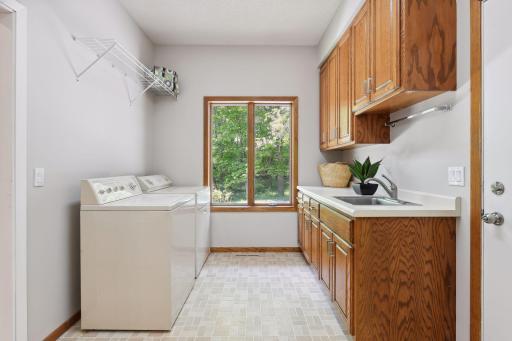 Large laundry room with many cabinets and sink