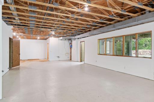 The other direction view - room stretches back behind door on left. Door on Right is finished office/flex room, far door on right is half bath - on the wall between the two is the rough in plumbing for a wet bar