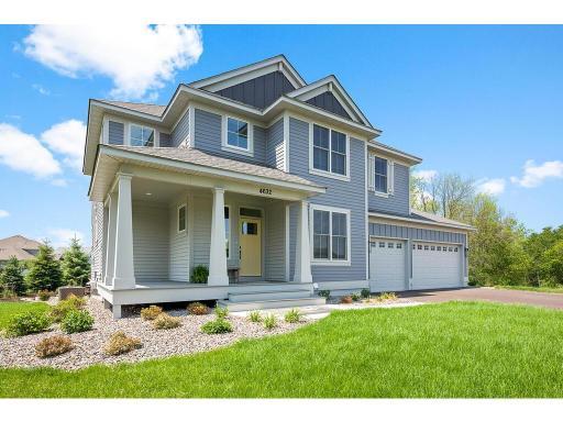 Charming wrap-around front porch adds inviting curb appeal to this beautiful home—perfect for relaxing or greeting guests.