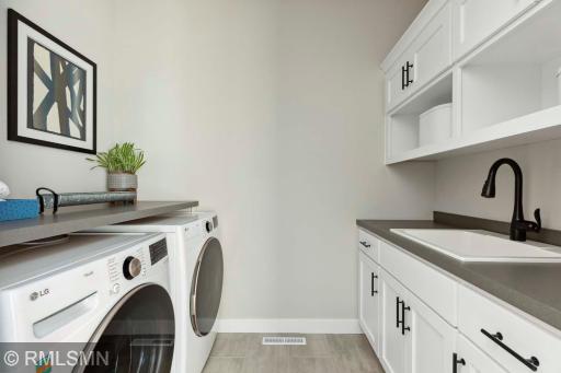 Laundry room w front load washer/dryer and cabinets