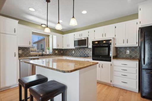 Granite counters, tile backsplash, updated cabinets, and convenient pull out storage throughout the refreshed kitchen!