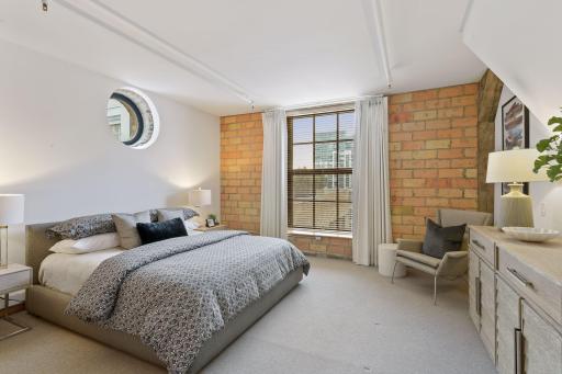 Upper level second bedroom suite with skyline views, a built-in desk area, and 3/4 bath with walk-in shower.