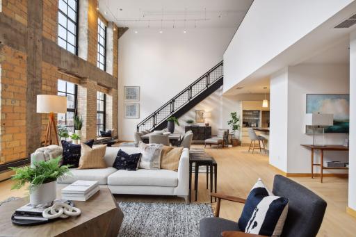 Open floor plan with main level living. The upper mezzanine level includes a lounge area, home office, 2nd bedroom suite, storage, and direct access to the rooftop deck.