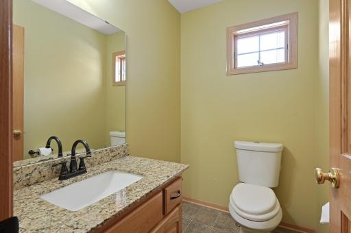 Main level half bathroom with storage cabinet and granite vanity top!