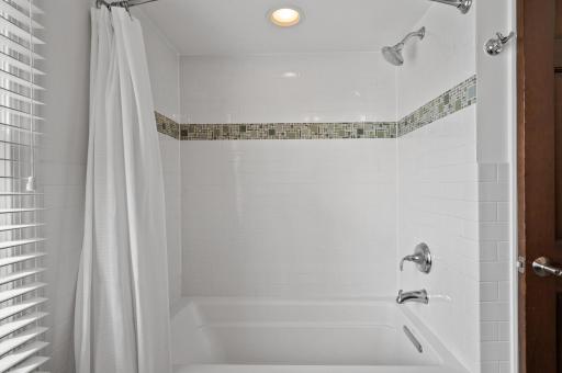The upper-level full bathroom tub and shower combination.