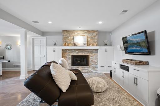 Lower-level family room with gas fireplace and dry-stack surround.