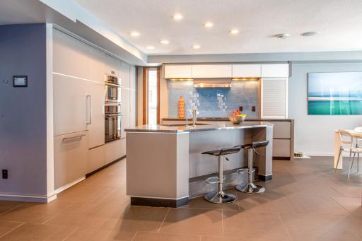 Eat-in Kitchen with custom European-designed cabinets with tons of storage, soft-close pantry doors with pull-out drawers, a built-in Gaggenau fridge, Electrolux appliances, a Barista Station, & modern articulating Karbon joystick faucet.