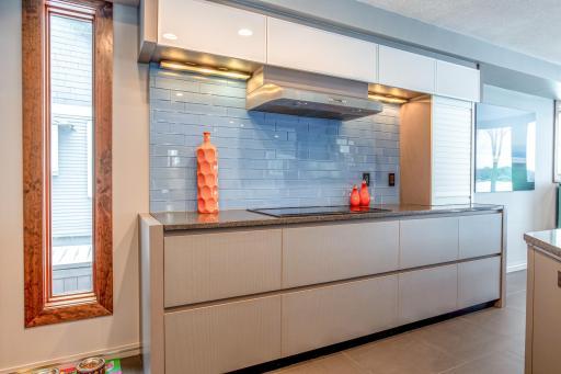Eat-in Kitchen with custom European-designed cabinets with tons of storage, soft-close pantry doors with pull-out drawers, a built-in Gaggenau fridge, Electrolux appliances, a Barista Station, & modern articulating Karbon joystick faucet.