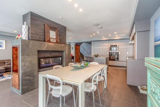 Stunning Dining Room featuring heated porcelain tile floors, see-thru fireplace, and stunning lake views - perfect for entertaining!