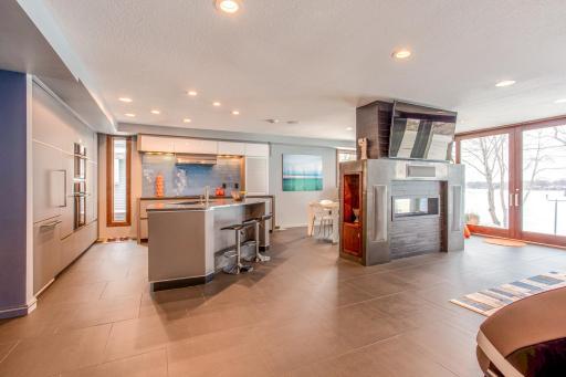 Eat-in Kitchen with custom European-designed cabinets with tons of storage, soft-close pantry doors with pull-out drawers, a built-in Gaggenau fridge, Electrolux appliances, a Barista Station, & modern articulating Karbon joystick faucet.