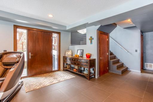 Welcoming entryway featuring a custom 42” wide door with side lights.