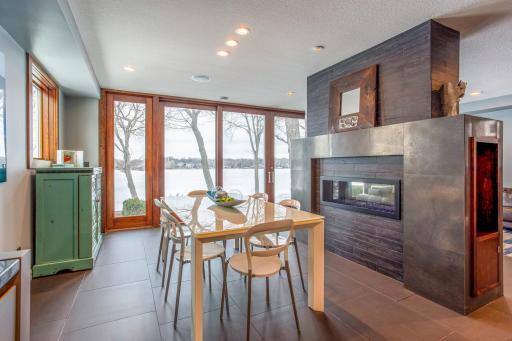Stunning Dining Room featuring heated porcelain tile floors, see-thru fireplace, and stunning lake views - perfect for entertaining!