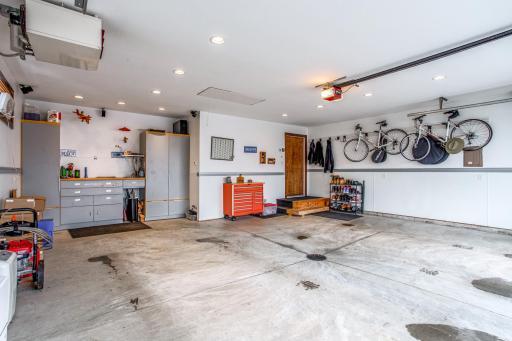 Oversized 2.5 stall heated Garage with 20' see thru Garage Door, floor drain, overhead storage, softened hot and cold water spigots, and a 10 gallon Air Compressor above with ceiling mounted retractable hose reel.
