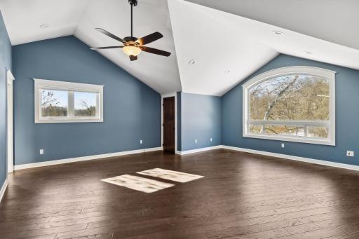 In the upper level, you'll find a 2nd primary suite, with stunning vaulted ceilings, gorgeous arched windows, and two enormous walk-in closets. And look at those views out the window!