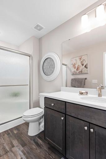 Owners bath has a 48" shower with seat, shower door, quartz countertops, upgraded faucet package and LVP flooring.