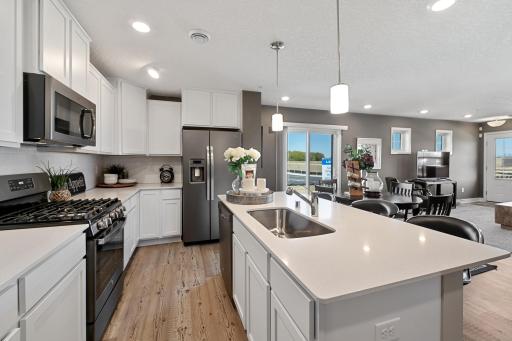 Welcome to the Franklin! This beautiful kitchen offers a large center island, quartz countertops, and ceramic subway tile backsplash. *Photos are of another model, colors and finishes may vary.