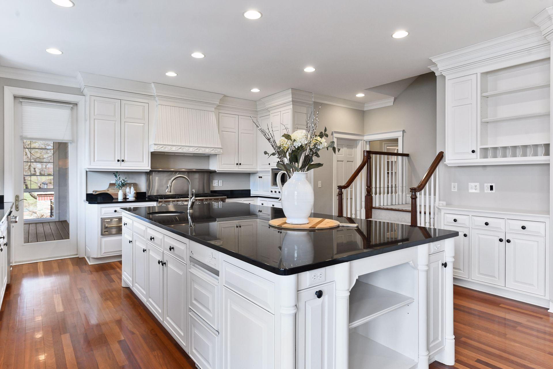 Plenty of cabinet space for storage, access to the screen porch, back stairs to the upper level, and gleaming wood floors are additional features of this gorgeous kitchen