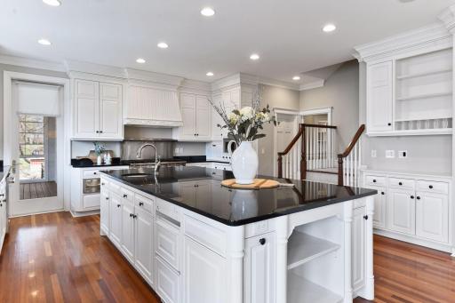 Plenty of cabinet space for storage, access to the screen porch, back stairs to the upper level, and gleaming wood floors are additional features of this gorgeous kitchen