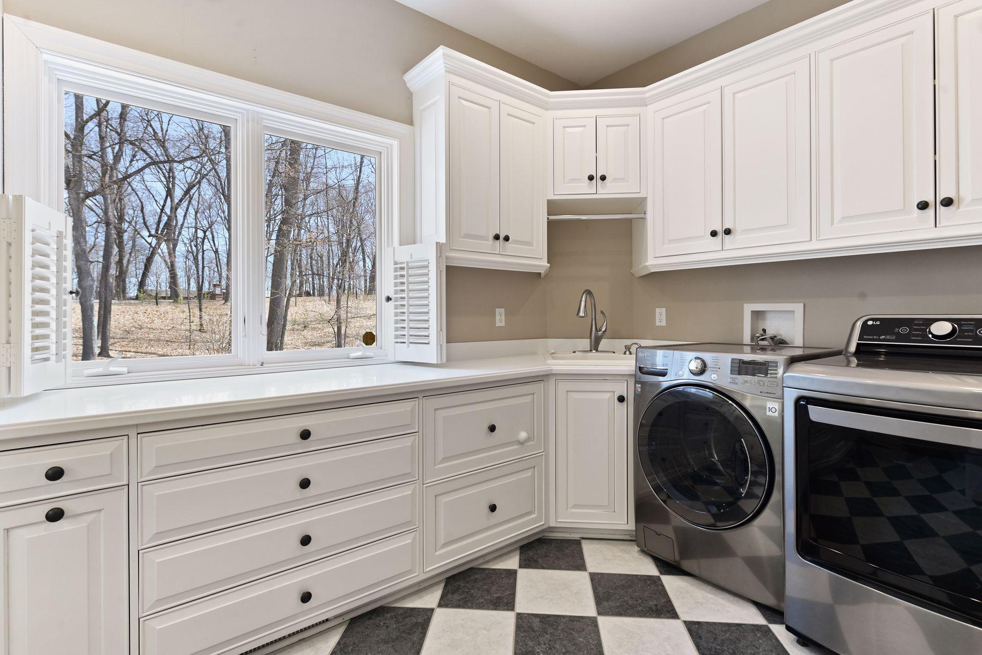 Main level laundry provides ample space for sorting and folding laundry while enjoying the nature view out the window