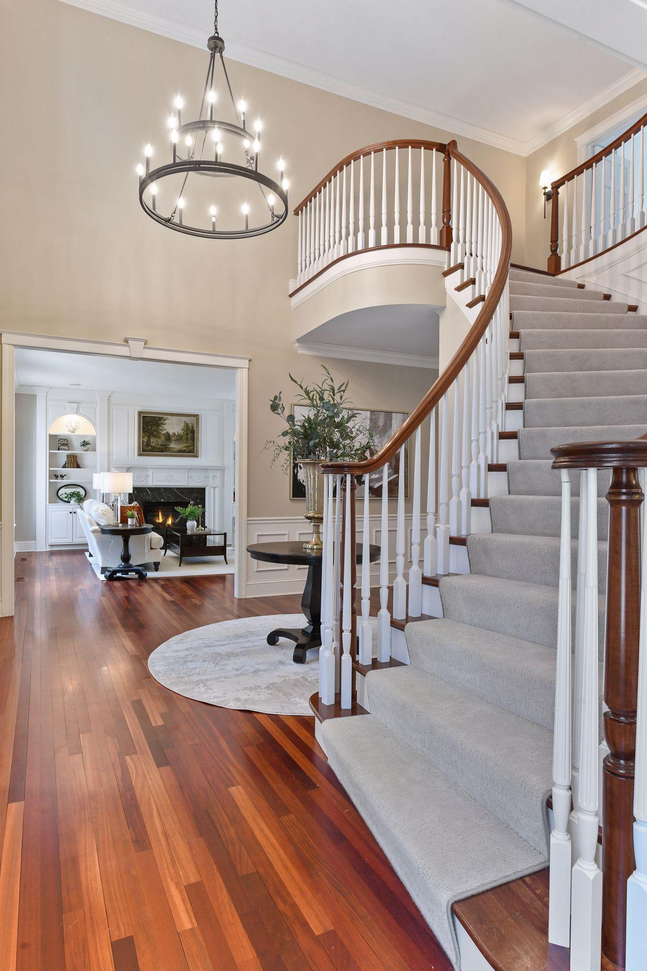 An elegantly sweeping staircase leads to the upper level