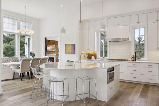 There is a large center island with rounded seating and Cambria countertops.