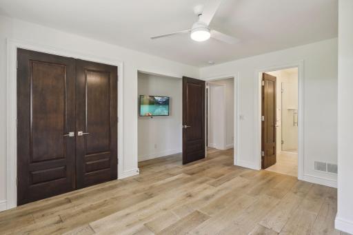 Down the hallway to the left is the first of three bedrooms. It has large windows and French door closet with an organization system.