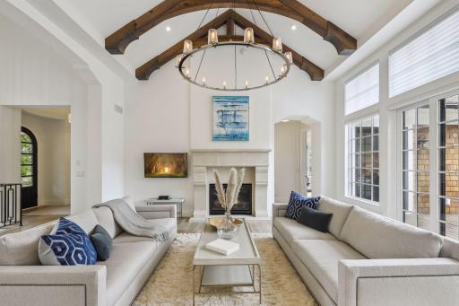 Looking up, a gorgeous oversized chandelier is flanked by wood beams accentuating the vaulted ceiling. The unique, modern style archways, tall baseboards and bullnose corners are just one more indication that no detail was overlooked.