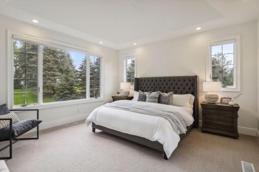 Off the living room is the private primary bedroom suite, which has French doors leading to the deck.