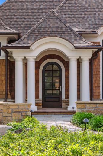The exterior also features copper gutters and cedar shake siding. Out front you will also notice a courtyard with walls made of Kasota limestone, stone pavers, and landscaping, adding to the overall curb appeal of the home.
