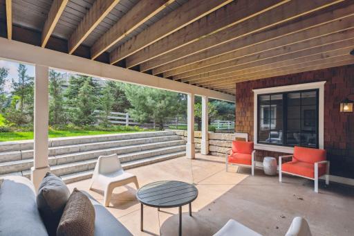 Underneath the deck is a concrete poured patio with a stone staircase leading to the yard.