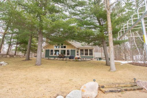 Backyard features beautiful towering pines and lakeside patio!