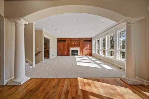 The generously sized living room presents a cozy gas fireplace and wall to wall custom built-in cabinetry.