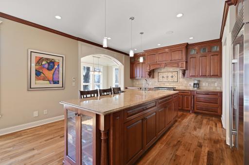 Fantastic gourmet kitchen is equipped with top of the line stainless-steel appliances, granite countertops, stone backsplash, a wealth of storage throughout, and adjoining informal dining space.