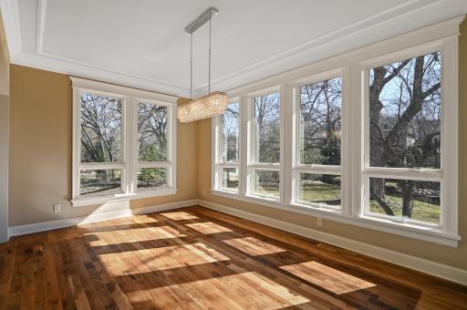 Formal dining room features wall to wall windows with a gorgeous creek view, stunning hardwood floors, and plenty of space for a large table and entertaining.