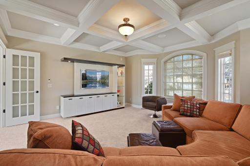 Main level office or family room has an intricate coffered ceiling, elegant glass French doors, and a large sun-filled bay window overlooking the front yard.