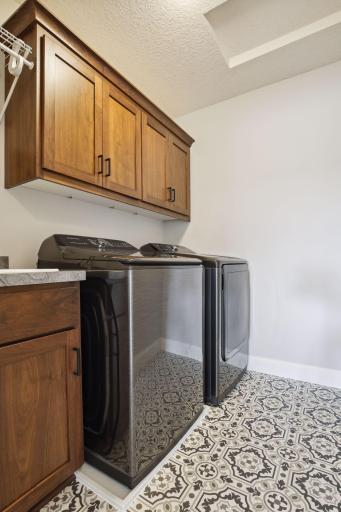 Laundry room is located on upper level as well, with upgraded cabinets and laundry sink