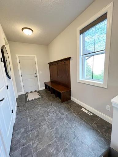 Entering back into the home from the screened porch, you'll see the door to the garage with a mudroom bench