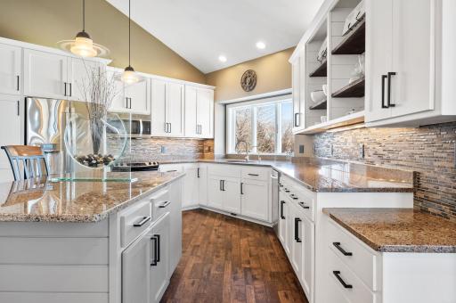 Cherry hardwood floors bring out the white cabinets