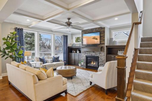Living room boasts detailed tray ceiling, gas fireplace and hand scraped hard wood flooring
