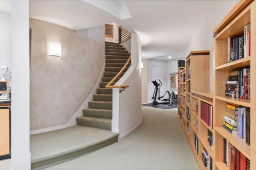 As you bid farewell to the primary bedroom, the gracefully curved staircase guides you to the lower level.