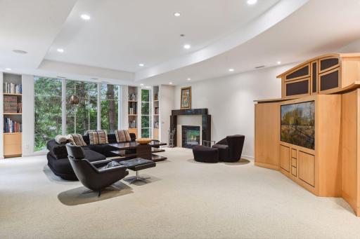 This walk-out level bathes the family room in natural light, courtesy of plentiful windows that offer captivating glimpses of the outdoors. An exterior door leads to another patio space, seamlessly extending the possibilities for outdoor enjoyment.