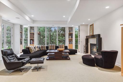 The family room embraces natural wood built-in bookcases, a contemporary fireplace, a built-in TV cabinet, and a wet bar, creating an inviting space to unwind and entertain.