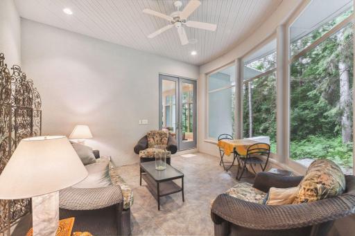 Indulge in moments of relaxation and serenity in the screened porch, accessible from both the hearth room and the primary bedroom, a serene vantage point to admire the enchanting wooded scenery and observe the local wildlife.