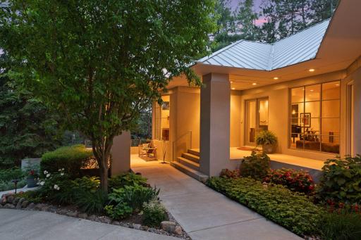 As you approach the residence, an expansive front patio beckons, inviting you to indulge in moments of leisure while shaded gracefully beneath an overhang.